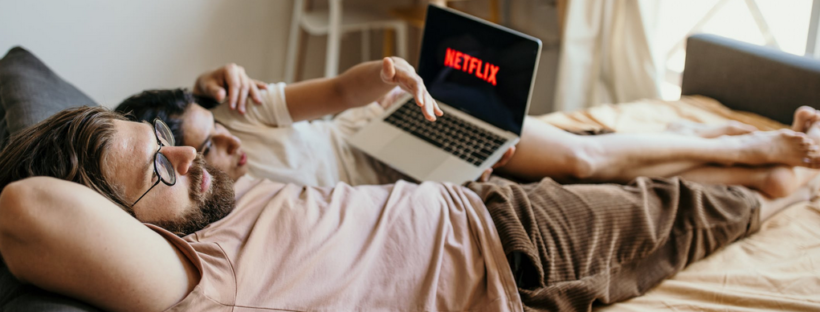 man and woman on bed with laptop
